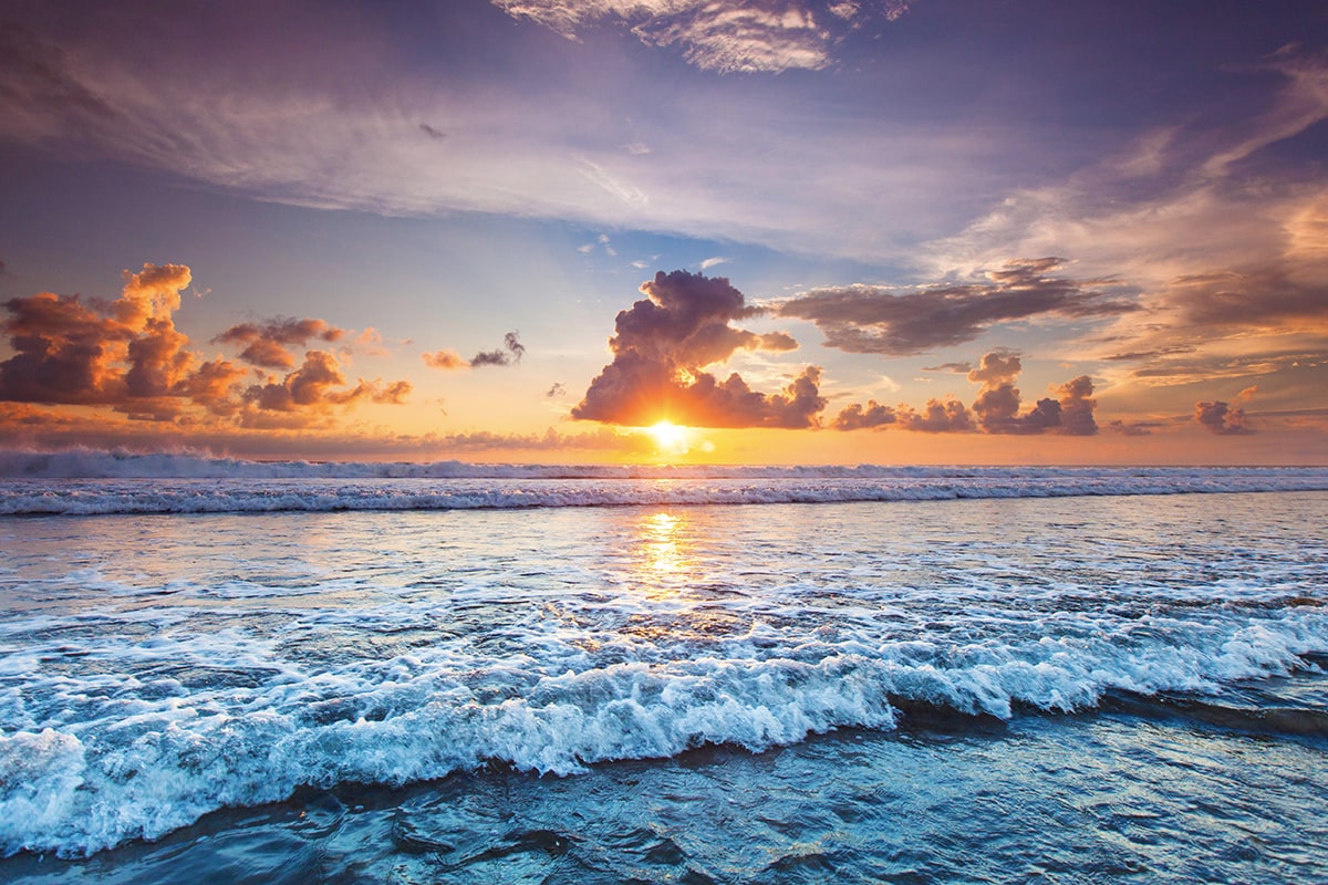 the sun setting at the beautiful beach in Bali