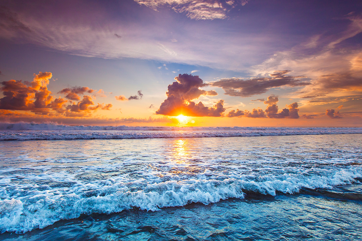 the sun setting at the beautiful beach in Bali