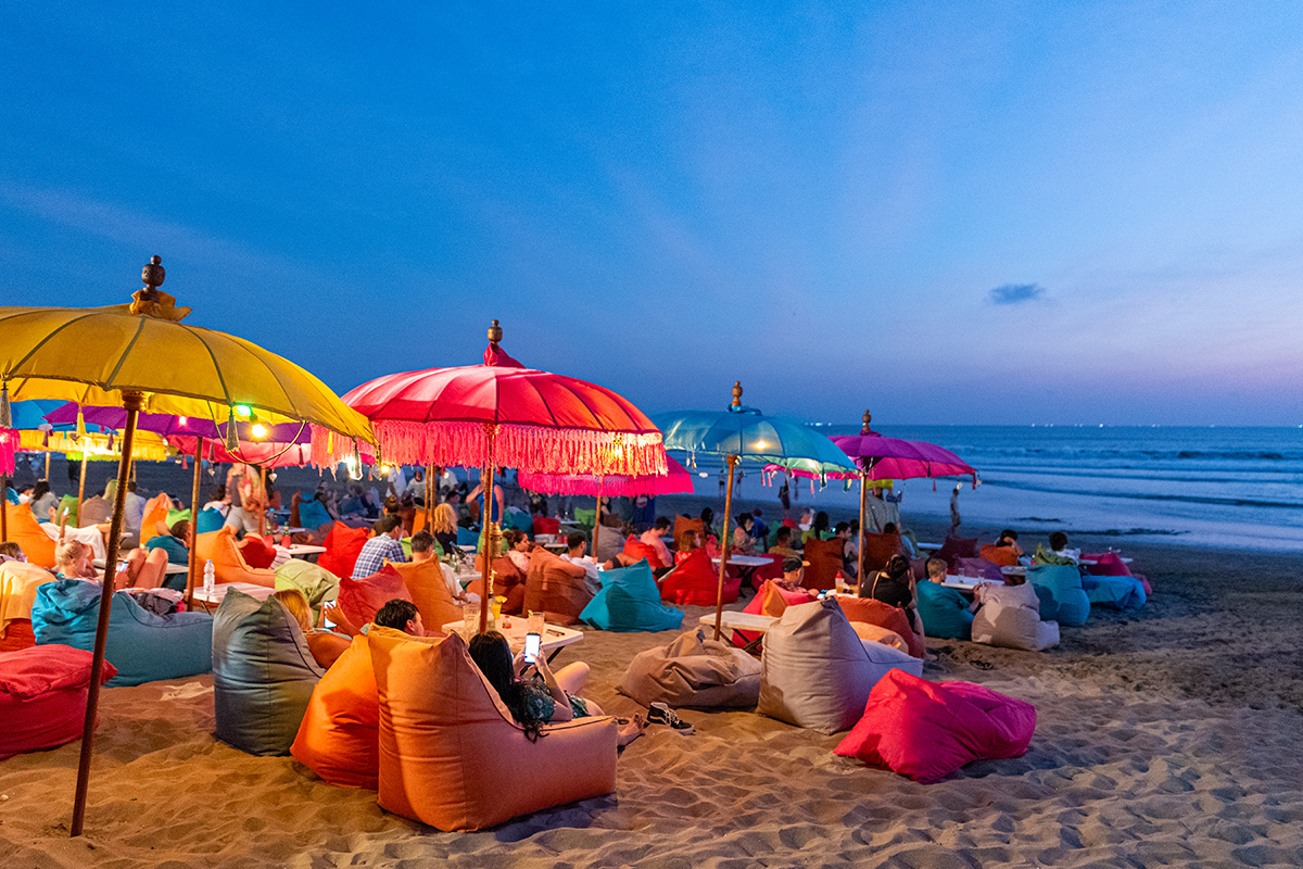 people sitting at colorful bean bags at Seminyak Beach Bali