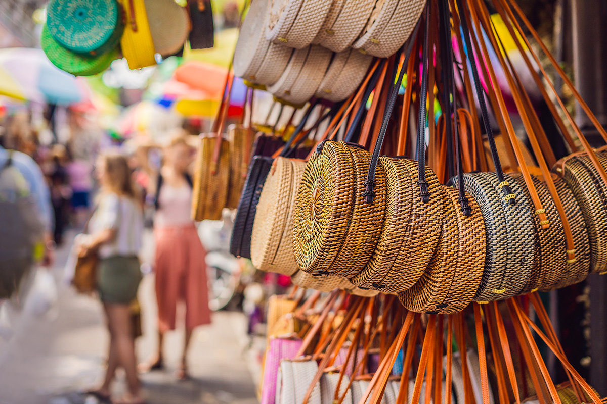 Various bags and accessories hanging in front of the street stalls