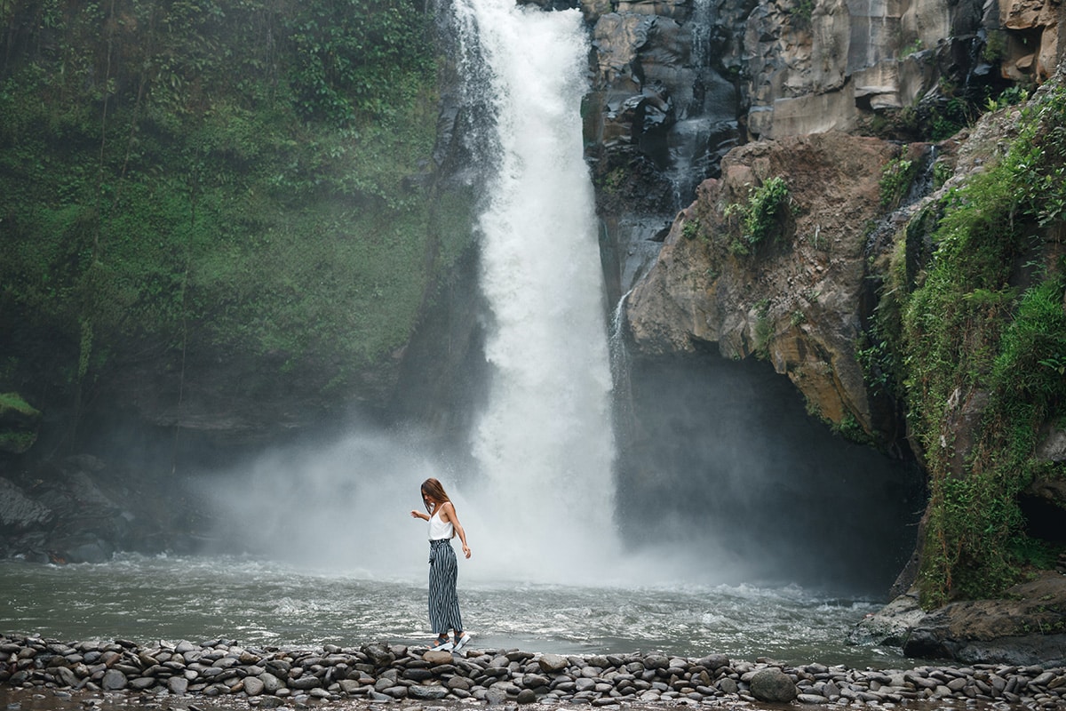 A woman standing near a waterfall