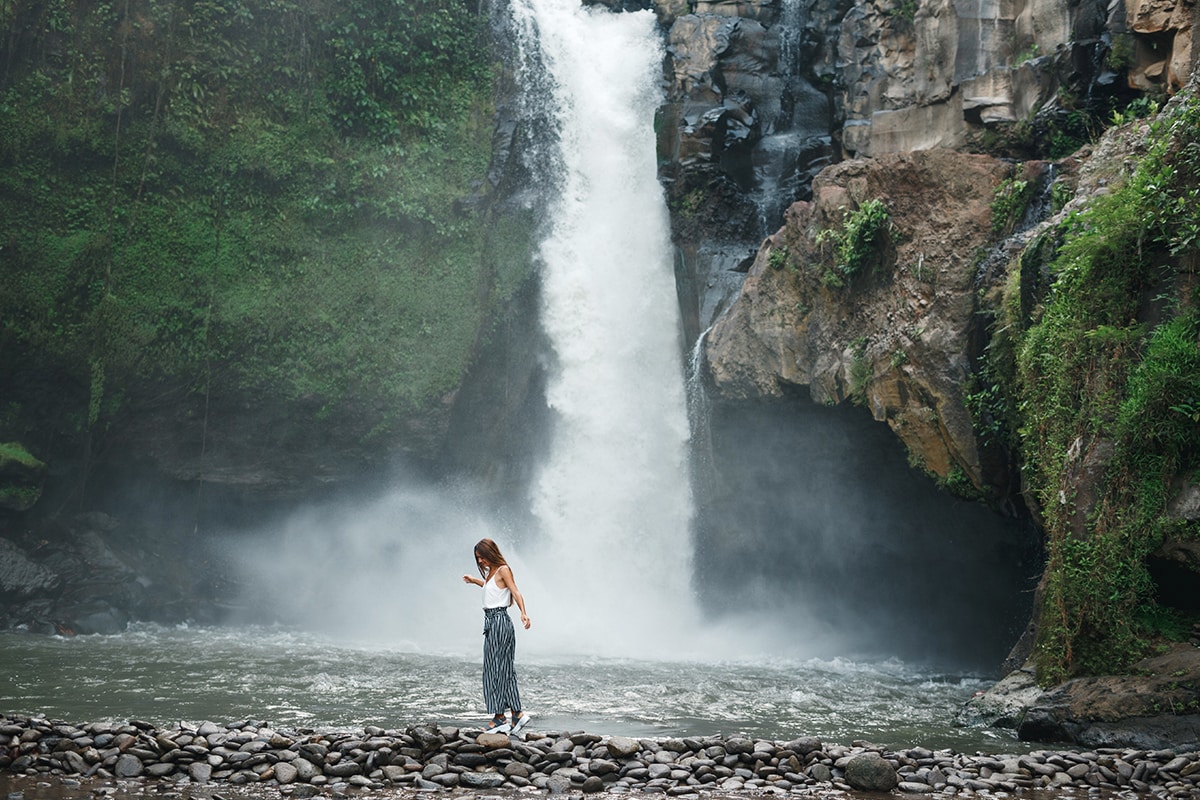 a foreigner standing in front of Tegenungan Waterfalls