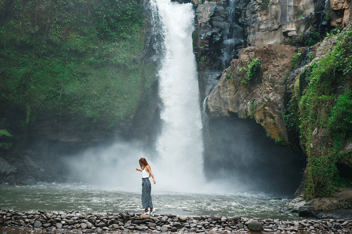 a foreigner standing in front of Tegenungan Waterfalls