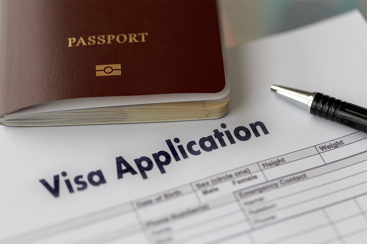 paper form of visa application with passport and pen
