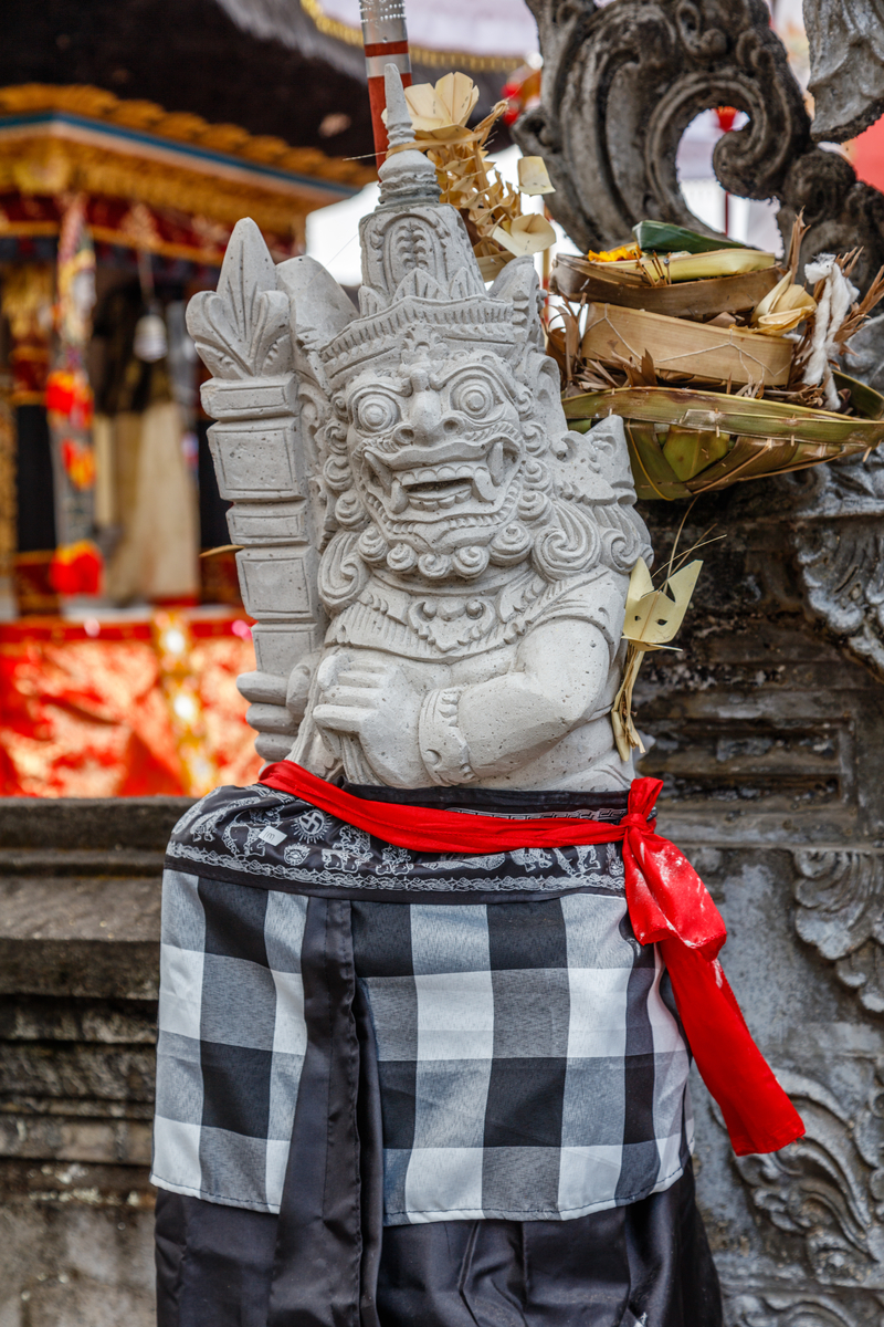 a Balinese textile Poleng tied to a Dvarapala statue