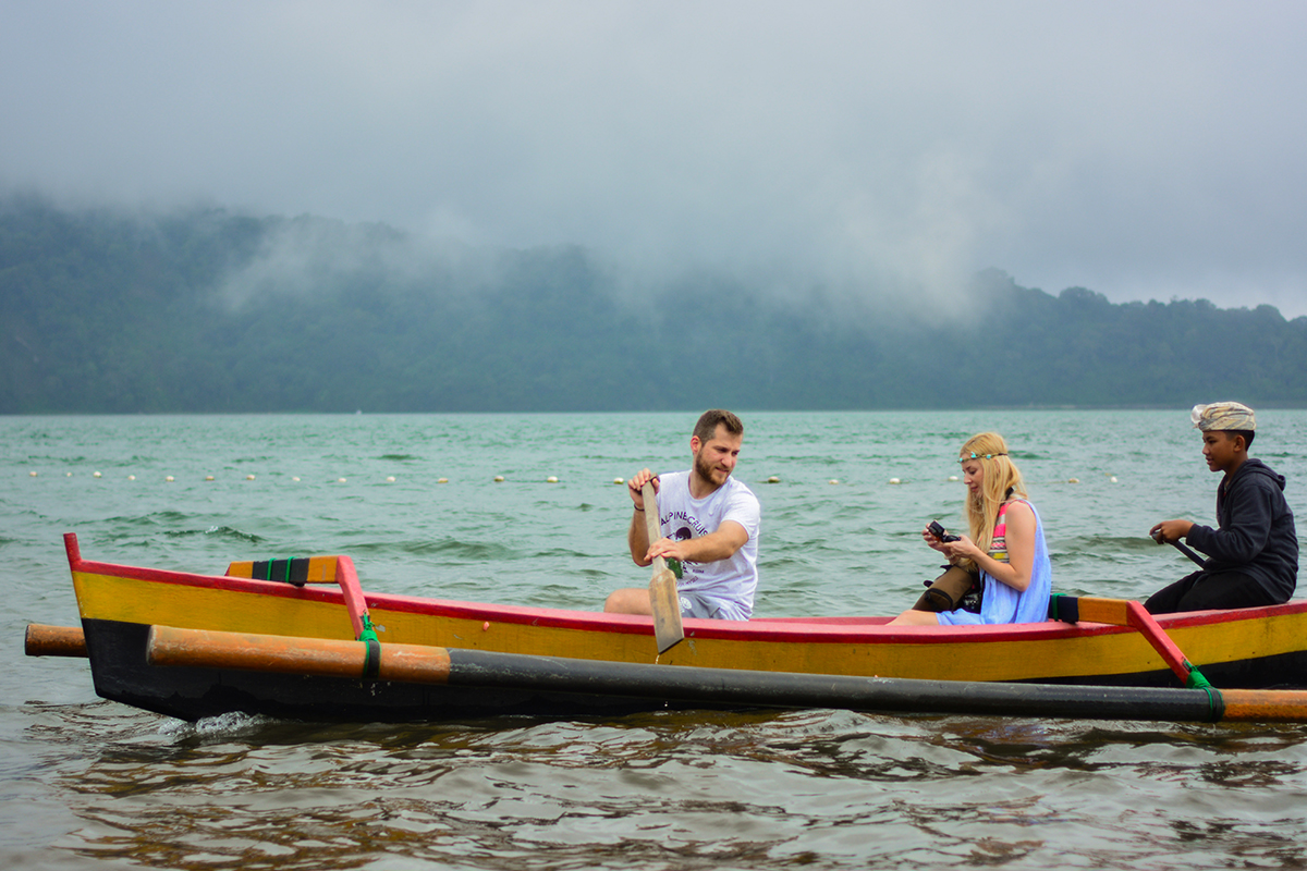 three person sailing on a canoe