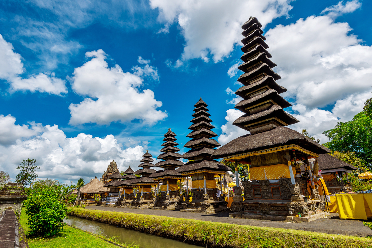 a female foreigner exploring Goa Gajah in Gianyar, Bali, serves as an archaeological place, traditional architecture with statues and stupas