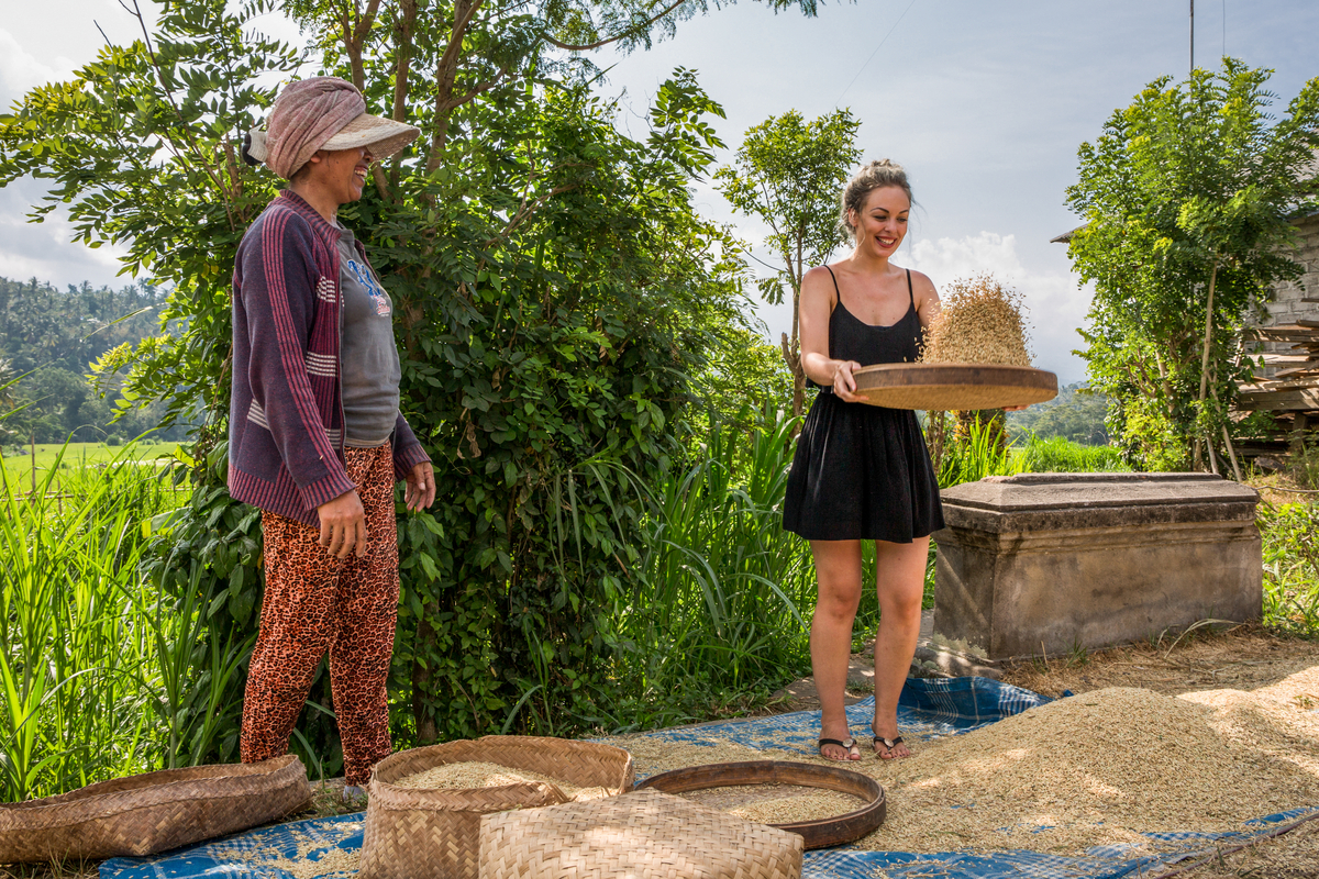 a tourist learning how to filter rice