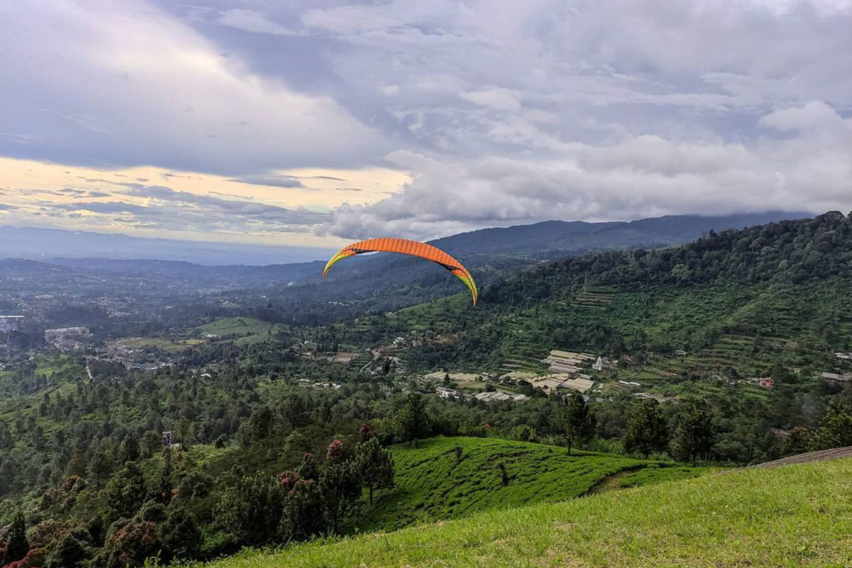 a guy paragliding above Tugu Selatan Village Bogor West Java