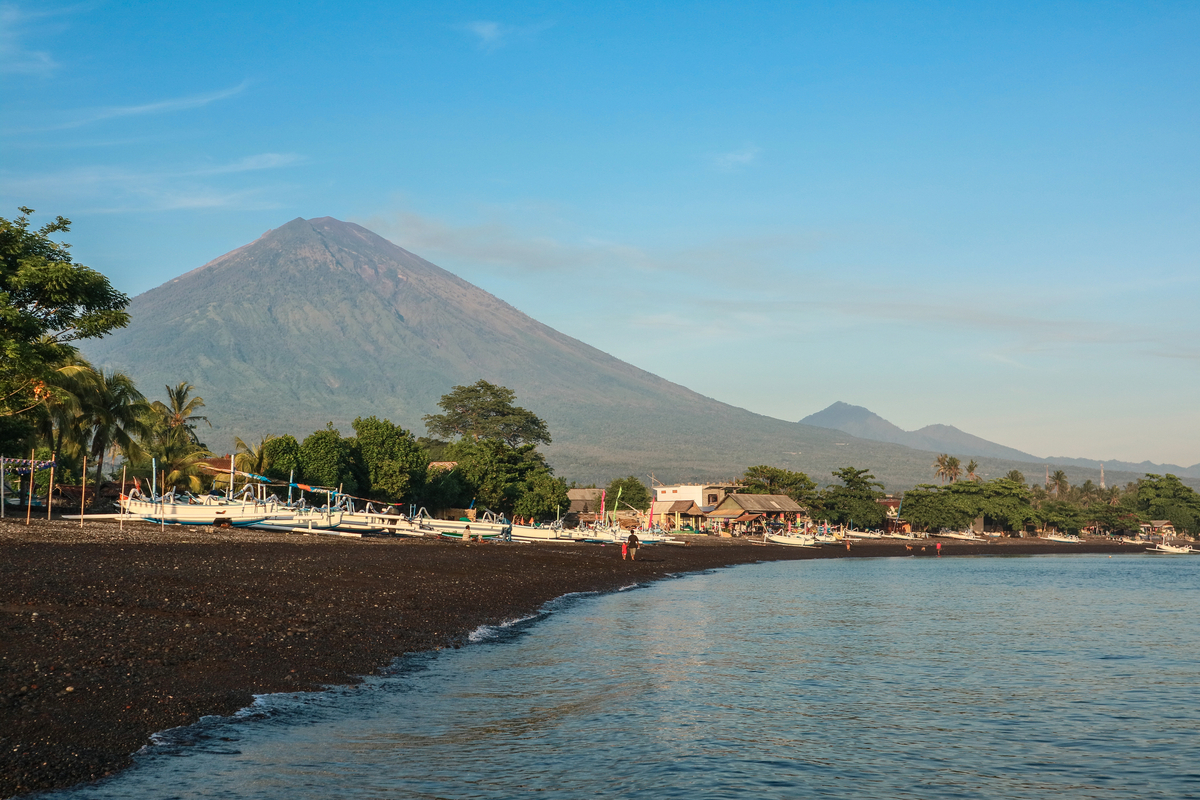 stunning Amed Beach in Bali with trees and grand mountain