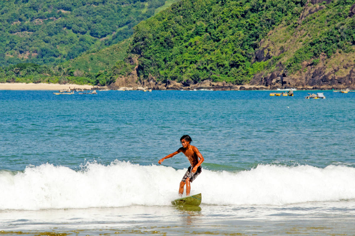 a man surfing on tides in Selong Belanak Beach, Lombok