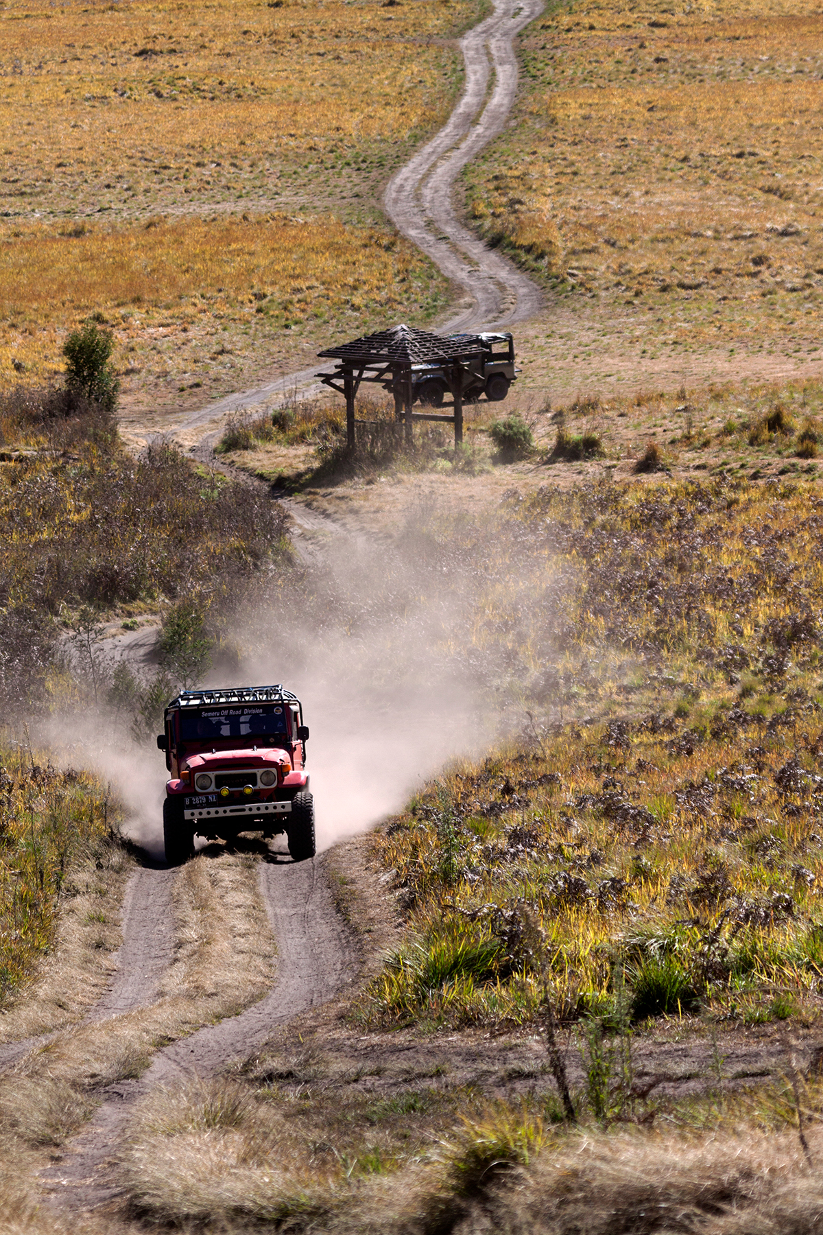 a red jeep is driving off-roads to the mountain