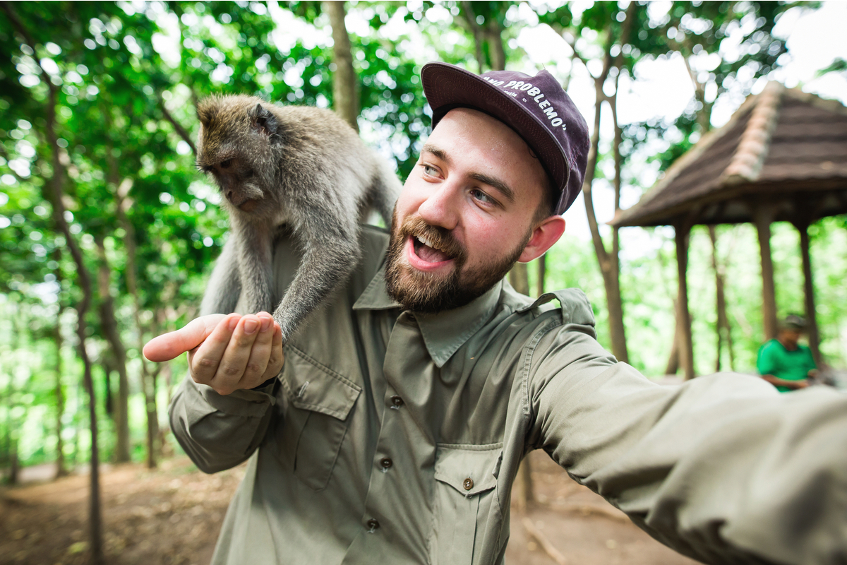 bearded tourist takes a selfie with a monkey in Ubud Monkey Forest