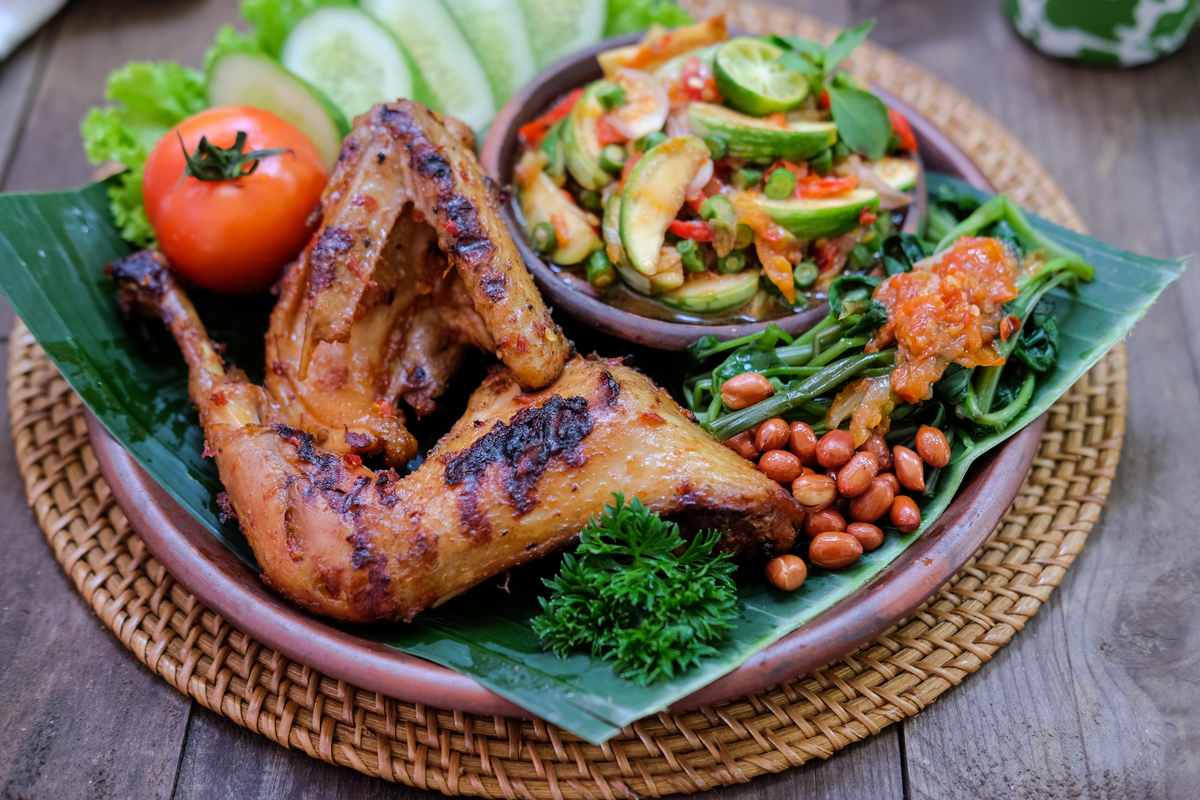 Taliwang Chicken served with sambal plecing and cucumbers lettuce tomato