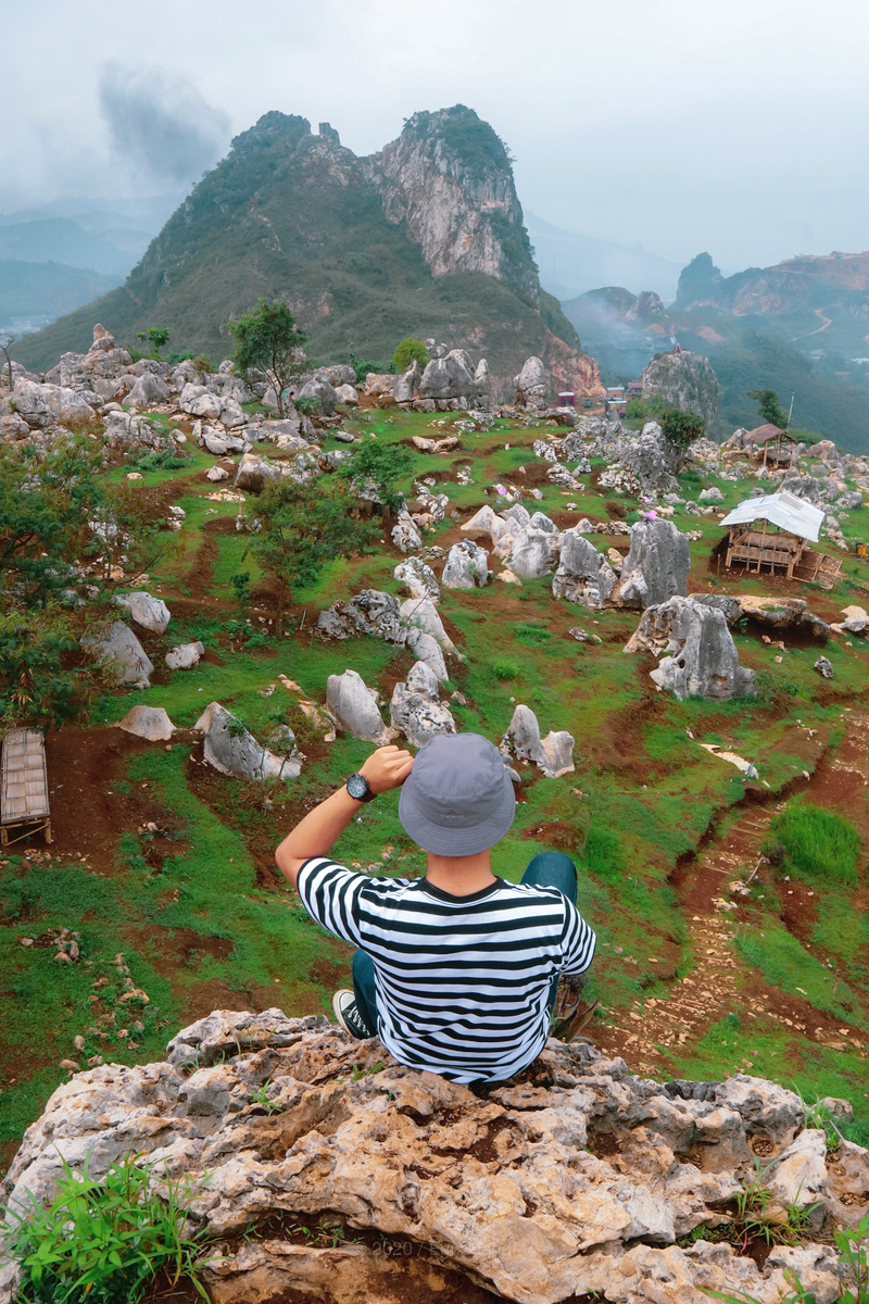 a man sits on top of a stone in Stone Garden Citatah