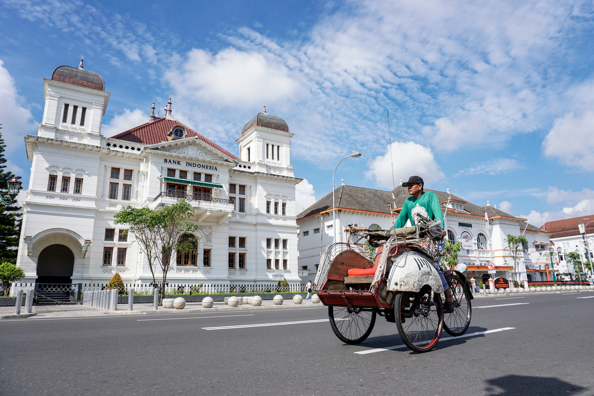 a man riding a Becak in Yogyakarta