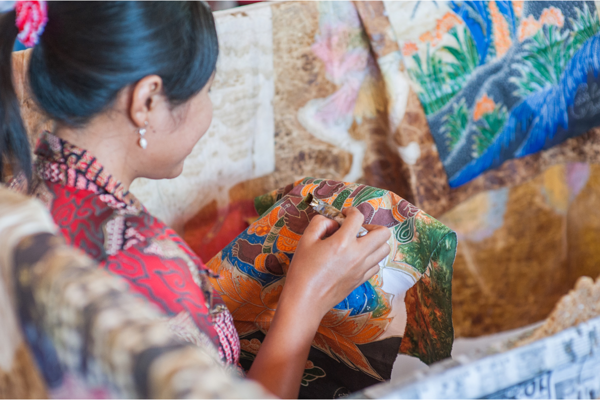 wanita yang sedang mewarnai batik