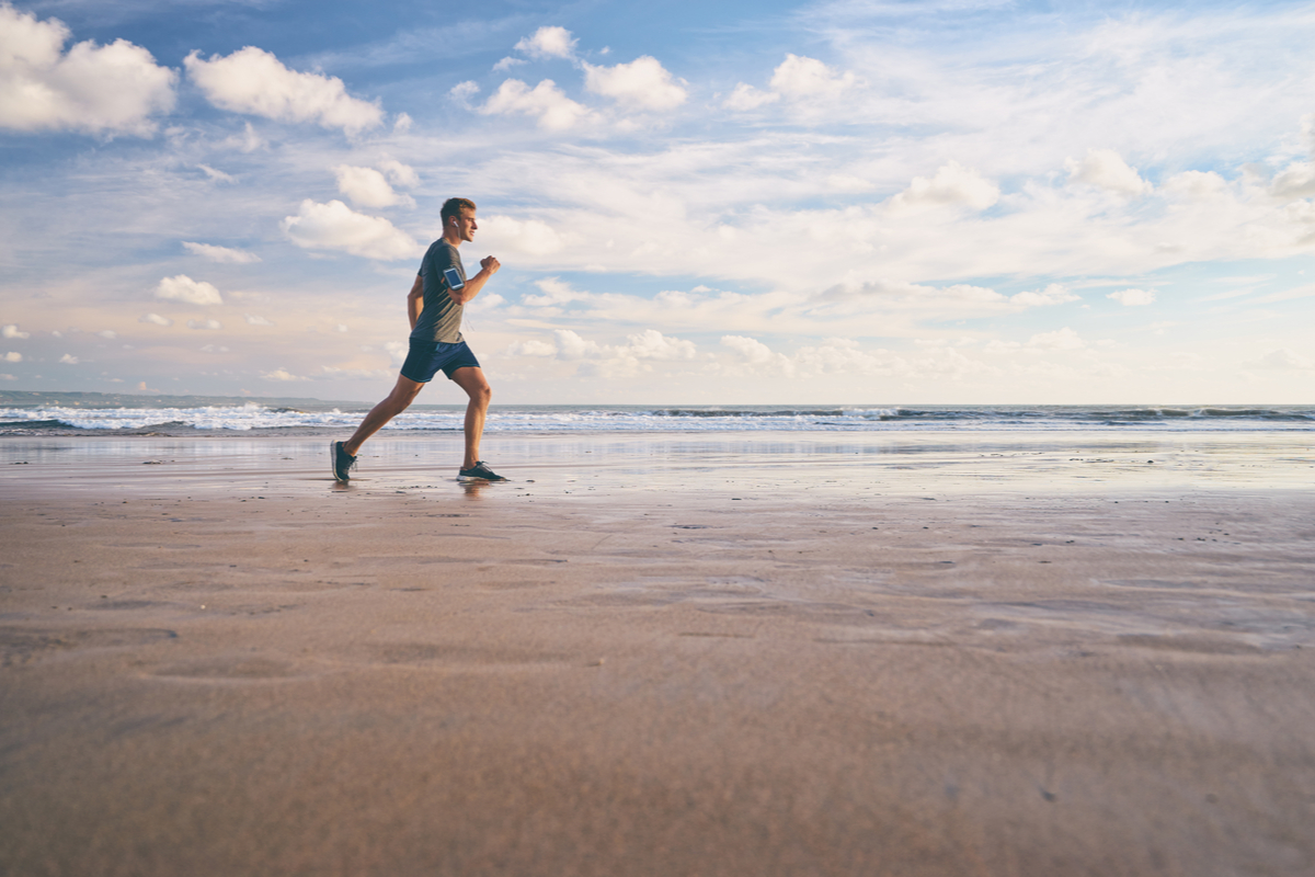 Seorang laki-laki berlari santai di tepi pantai