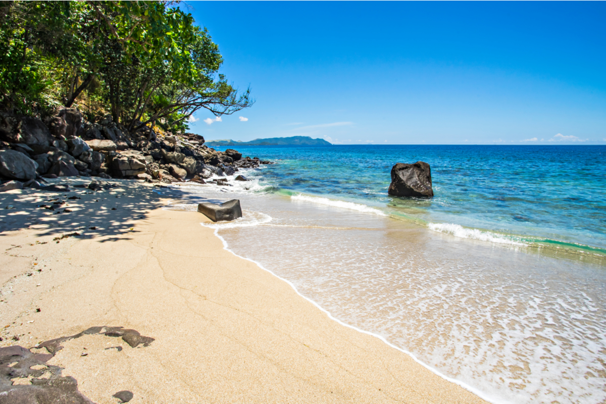 a man surfing on tides in Selong Belanak Beach, Lombok