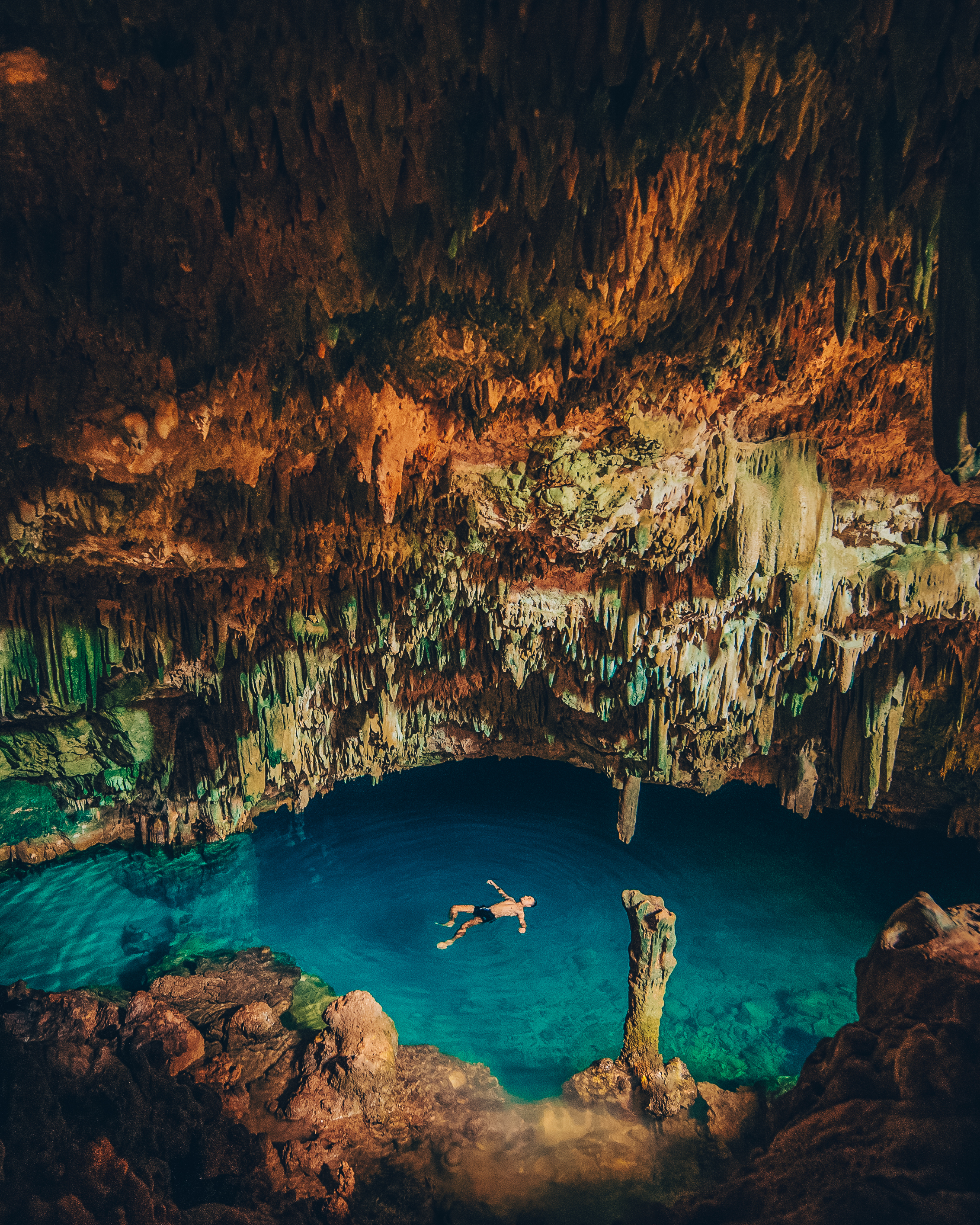 Seorang wisatawan sedang berenang di kolam Gua Rangko